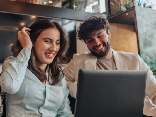 mujer en pareja tomandose el cabello frente a una laptop